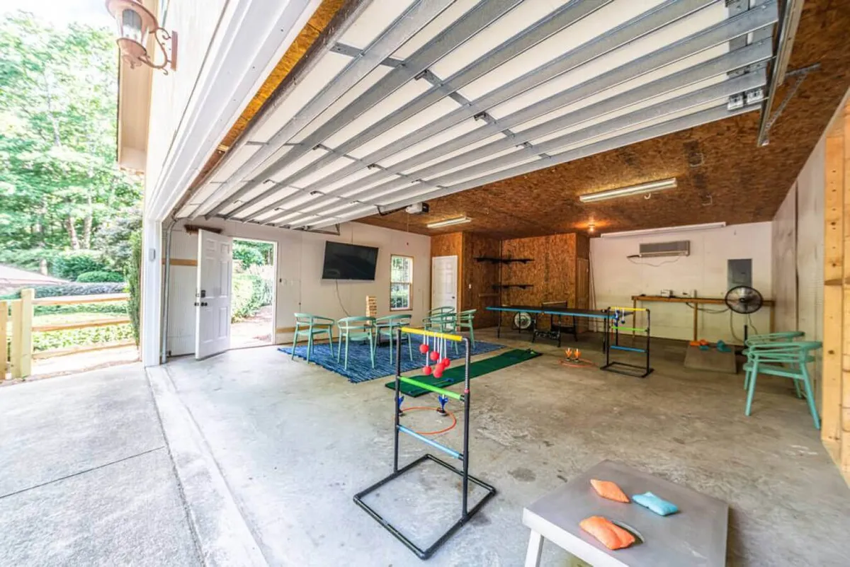 A vibrant game room featuring multiple game tables, a seating area, television, and colorful play items, inviting families to enjoy friendly competition and shared laughter indoors.