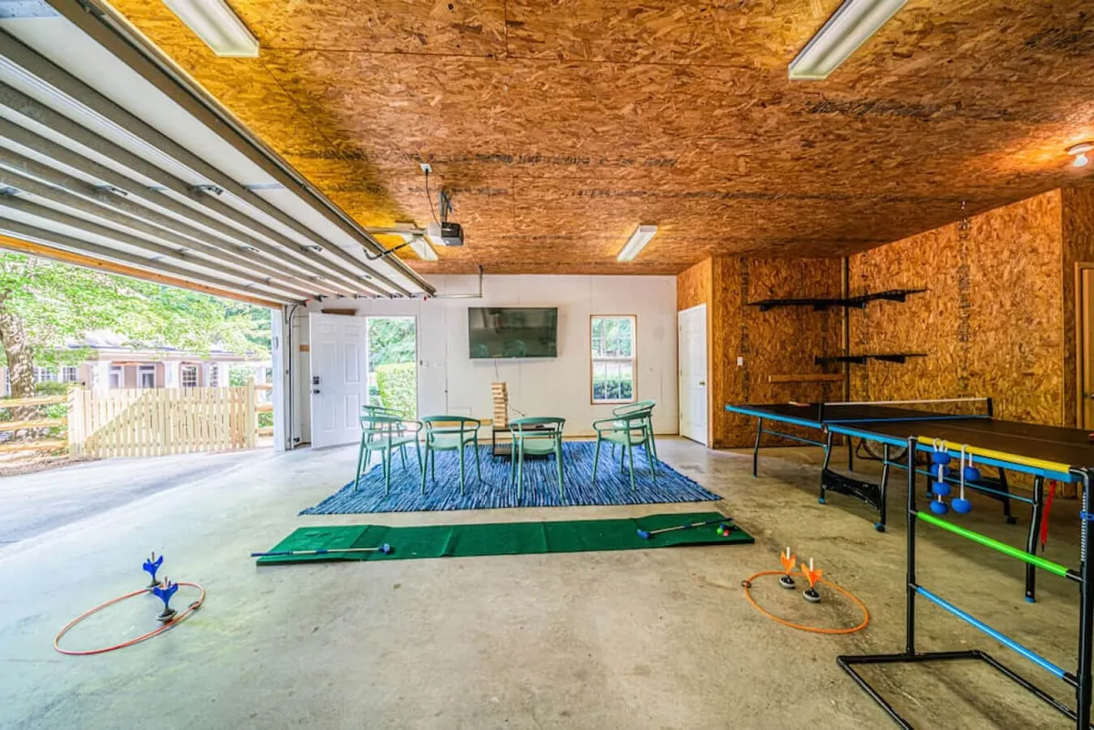 This image shows a bright, inviting media/game room with a table and chairs, a television, and a visible game setup, creating a space perfect for game nights, movie watching, and family fun. The scene conveys the lively, social atmosphere central to a recreation-focused space.
